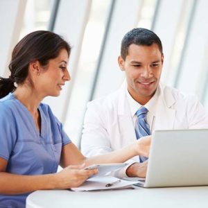 Photo of healthcare professionals looking over computer and tablet