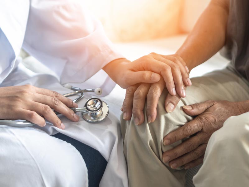 photo of clinician's hand holding on to a patient's hand